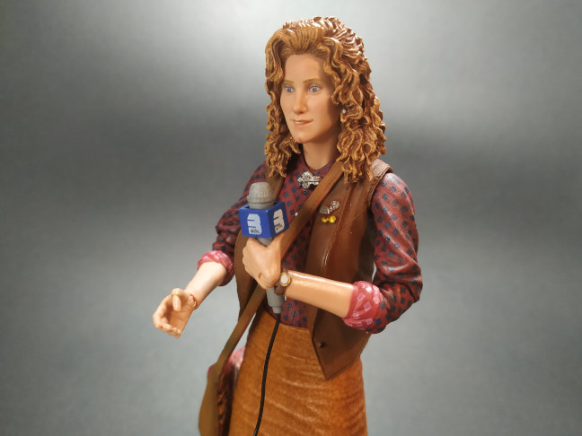Imagen de la figura de April con su bolso y micrófono