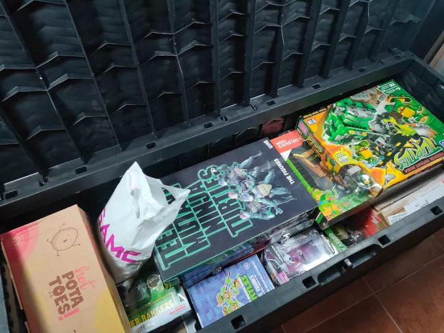Imagen un baul abierto con su contenido y como ordenar juguetes