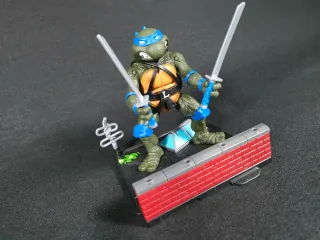 Imagen de la figura de Leonardo de Las Tortugas Ninja Remastered junto con la base que forma el diorama