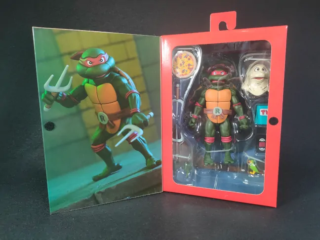 Imagen detallada del packaging abierto de la figura de Raphael de las Tortugas Ninja VHS de NECA