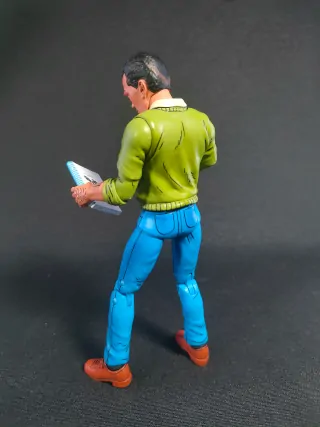 Imagen desde 3/4 de la parte trasera de la figura de Jack Kirby versión Mirage de NECA