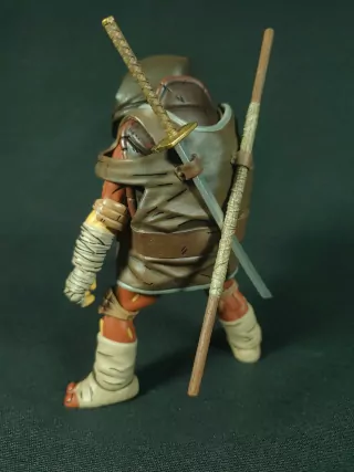 Imagen trasera de la figura de Moja con su ropa táctica y armas